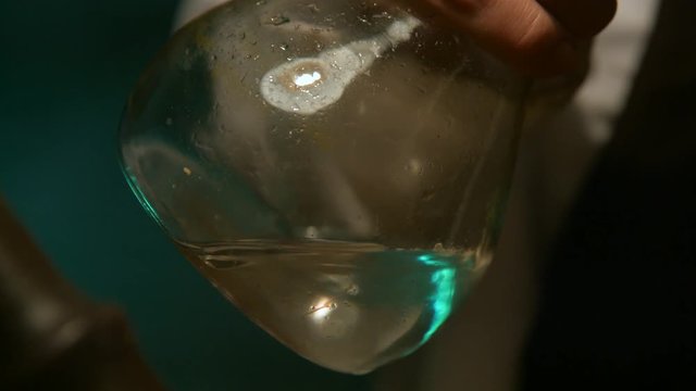 Scientist pours liquid in a flask