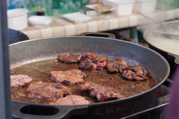 Fried meat in a pan at Christmas market