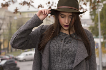 Fashionable model in green hat and coat at the street