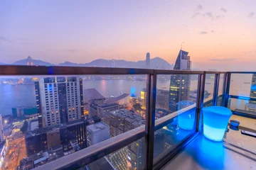 Badkamer foto achterwand Hong Kong, China - January 1, 2016: spectacular aerial view of Victoria Harbor skyline at sunset from the rooftop of Eye Bar, a modern skybar inside iSquare shopping center in Kowloon, Hong Kong city. © bennymarty