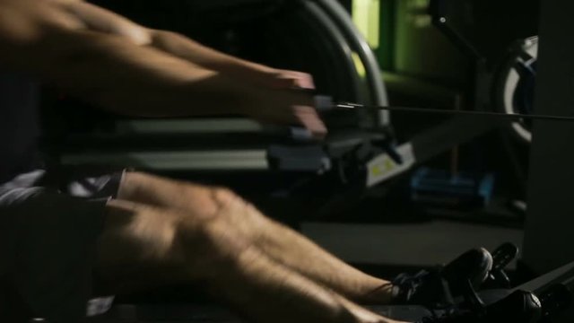 Muscular man sporty workout on training simulator in crossfit gym