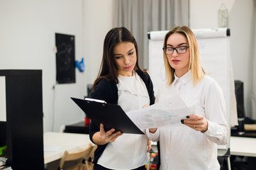 Two beautiful young executives reading some papers