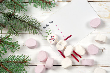 Christmas card with fun marshmallow snowman in green cup, tree