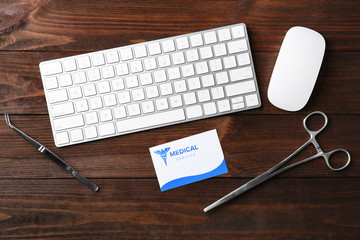 Keyboard, medical supplies and card on wooden background