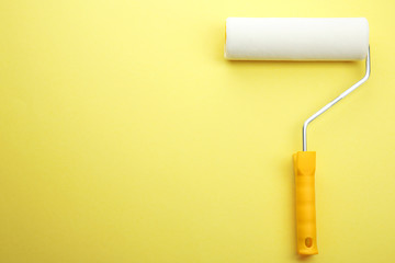 Painting roller on yellow background