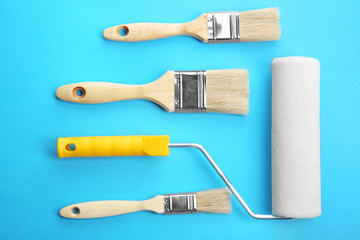 Painting roller and brushes on blue background