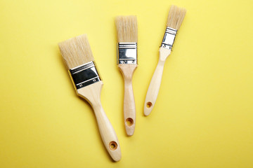 Three brushes on yellow background