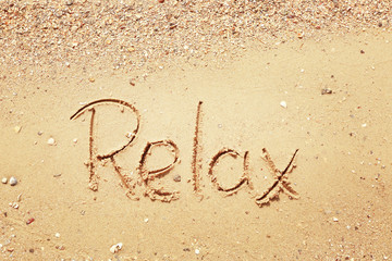 Word RELAX on beach sand