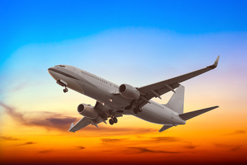 Fototapeta na wymiar Commercial airplane flying with beautiful sunset background
