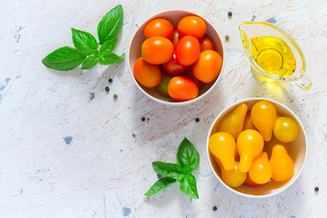 Red and yellow cherry tomatoes in bowls. Top view with copy spac