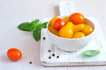 Bowl with yellow and red cherry tomatoes, copy space