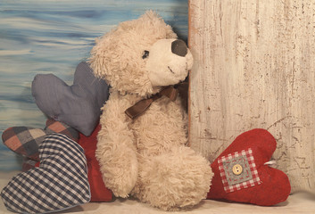 A teddy bear and hearts. Teddy bear as a gift for Valentine. Happy Valentines day - vintage style - soft focus
