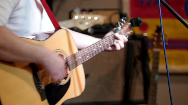 Man playing acustic guitar at rock concert