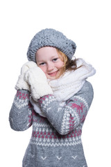 Happy cute kid posing in the studio isolated on white background. Wearing winter clothes. Knitted woolen sweater, scarf, hat and mittens.