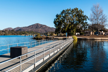 Fototapeta na wymiar Fishing pier at Lake Murray in San Diego, California with Cowles Mountain in the background. 