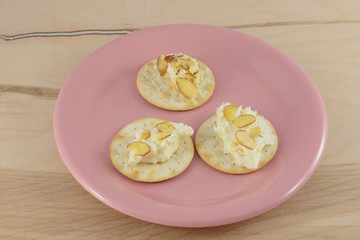 Slices of white chocolate amaretto cheese ball with almonds on table water crackers