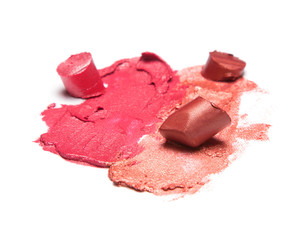 Samples of smeared and sliced lipstick on white background