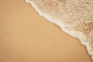 Close up tropical beach with smooth wave and sand texture background.