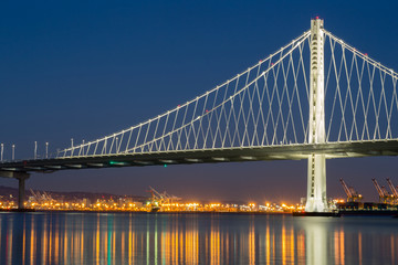 The New San Francisco's Bay Bridge East Wing at Night with Port of Oakland reflections. Taken from...
