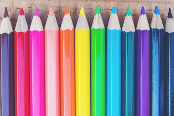 Close up of color pencils with different color over wood backgro