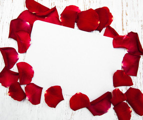 Red roses petals with card