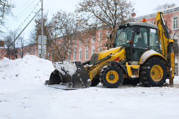 tractor for snow removal is parked on a city street