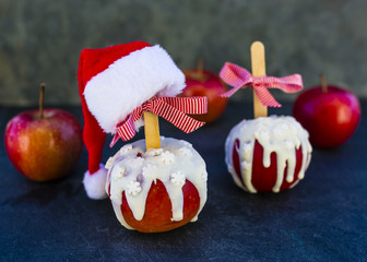 Christmas red delicious apples in white chocolate and Christmas decoration on dark background.