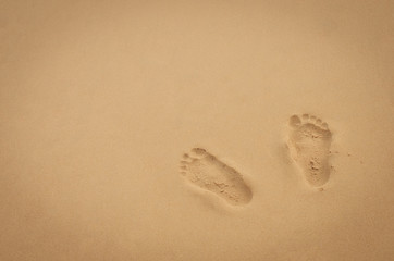 Copy space of footprint on sand beach texture background.