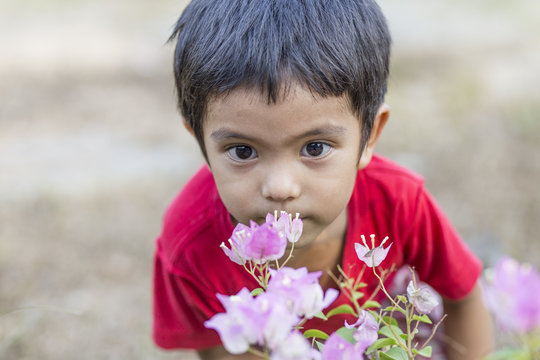 Little Boy Smelling Flowers