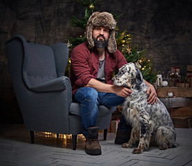 A man in fur hat and Irish setter dog.
