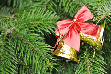 Closeup of Christmas-tree with gold bells and red bow decoration