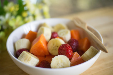 fruits salad on Wooden Background. Fork and Spoon