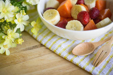 fruits salad on Wooden Background. Fork and Spoon