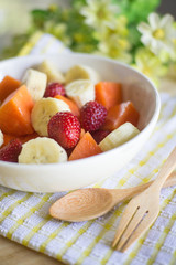 fruits salad on Wooden Background. Fork and Spoon