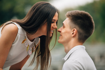 Naklejka premium Couple in love. Portrait of beautiful couple in love looking at each other and smiling outdoors. Summer time. Love story. 
