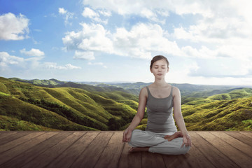 Fototapeta na wymiar Young asian woman doing yoga lotus meditation on the wooden floor