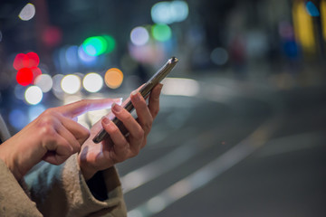 Woman Using Smartphone on European Christmas Market. Girl Enjoying