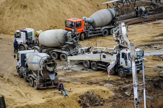 builders build a foundation from cement  to a new building ground truck mixer hard working