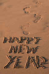 text happy new year in the sand of a beach