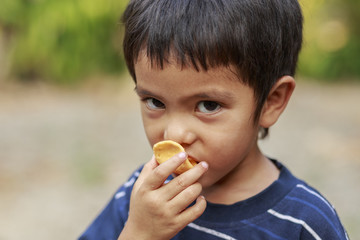 Asian little boy eating crisp rice