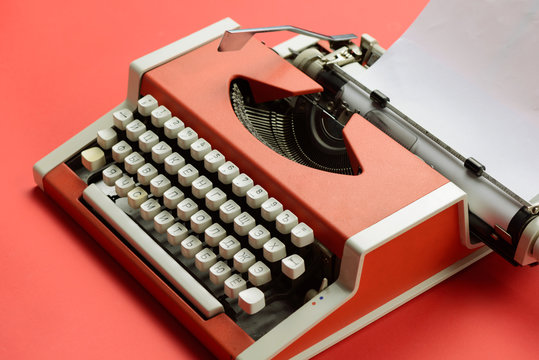 Red vintage typewriter with white blank paper sheet