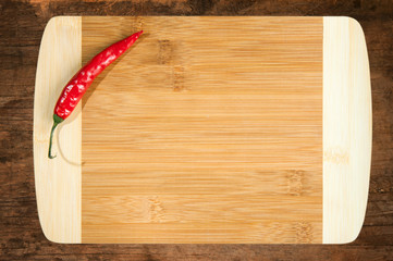 Chili Pepper on cutting board. Wooden kitchen whit restaurant menu.