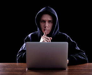 Hooded computer hacker stealing information