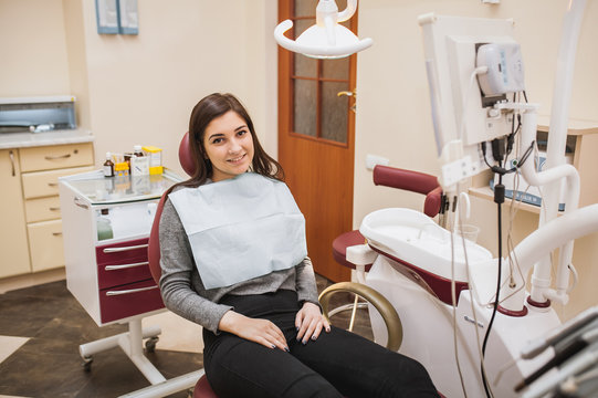  brunette treats teeth, beautiful girl at the doctor