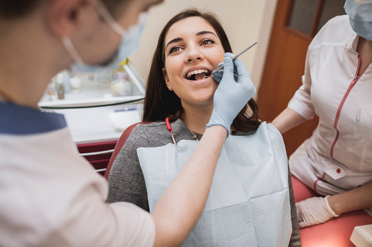  brunette treats teeth, beautiful girl at the doctor