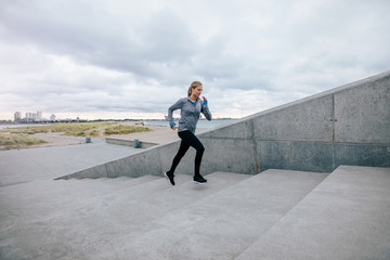 Fit young woman running up the steps