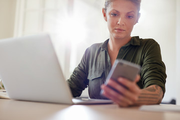 Fototapeta premium Attractive young woman using smart phone