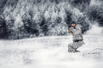 Fototapeta na wymiar Male hunter in camouflage looking for his target or prey .Winter