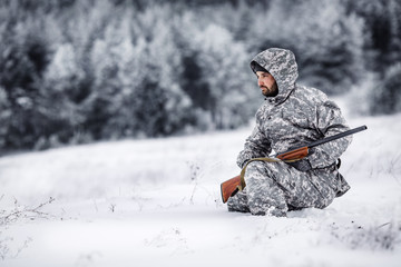 Male hunter in camouflage looking for his target or prey .Winter