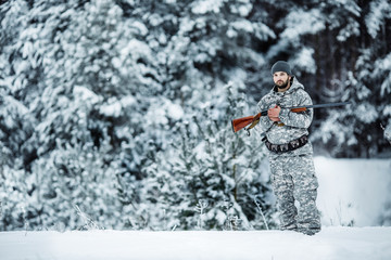 Male hunter in camouflage looking for his target or prey .Winter